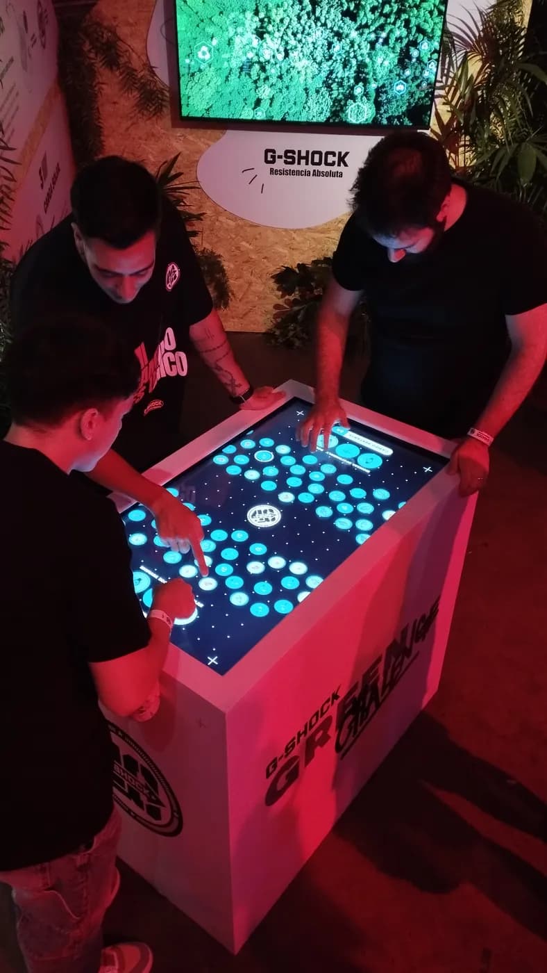 Participantes jugando en una mesa táctil
