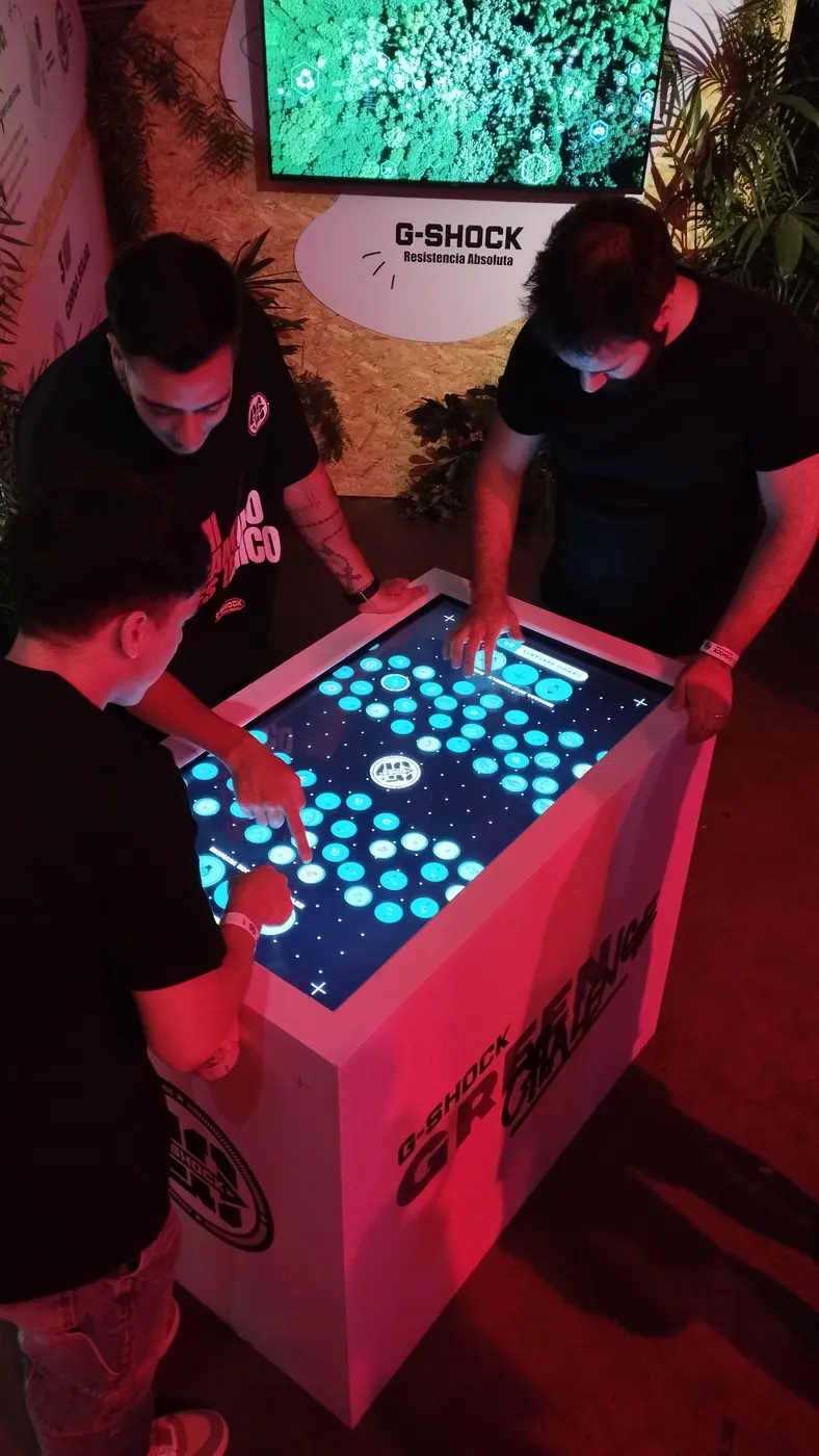 Participantes jugando en una mesa táctil